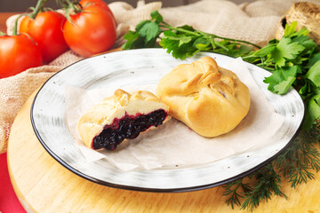 Bun filled with currant jam on a plate. Bakery