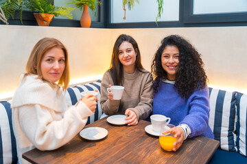 Friends taking coffee together in a cute cafeteria