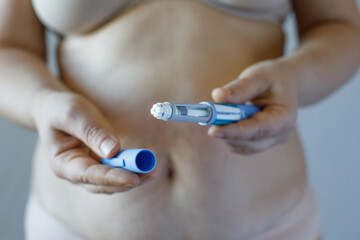 Weight loss and diabetes concept. Woman opening Semaglutide Injection pen or insulin cartridge pen.