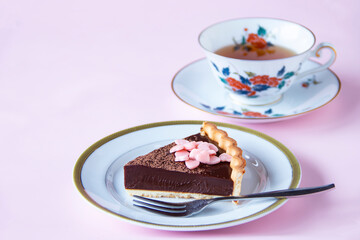 バレンタインのお菓子　手作りチョコレート・タルトとハート型のピンクのチョコレートと紅茶（ペールピンクの背景）
