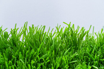Close up of vibrant green artificial grass turf in residential. white background.