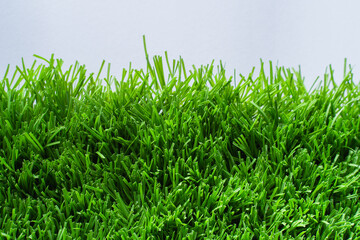 Close up of vibrant green artificial grass turf in residential. white background.
