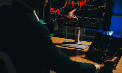 Thoughtful focused successful caucasian male stock investor, broker, financial adviser, sits at work desk, looks at computer, pensively analyze risks and prospects, rise or fall of cryptocurrency coin