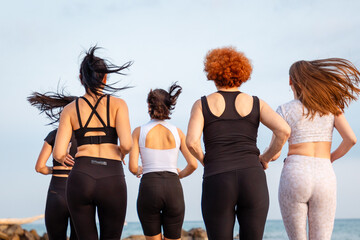 Wellness. Rear view of group of jogging women. Close up of backs. Concept of healthy lifestyle and cardio fitness class - obrazy, fototapety, plakaty