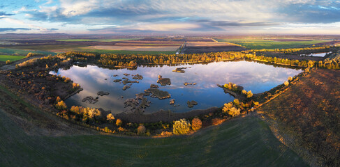 Forest Lake at sunset. Wild Lake in swamp, drone view. Rural landscape with lakes. Forest at bog.