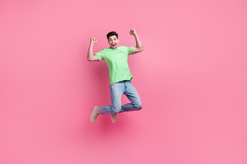 Fototapeta na wymiar Full length photo of sportsman jumping trampoline wear green t shirt enjoying his football team victory isolated on pink color background