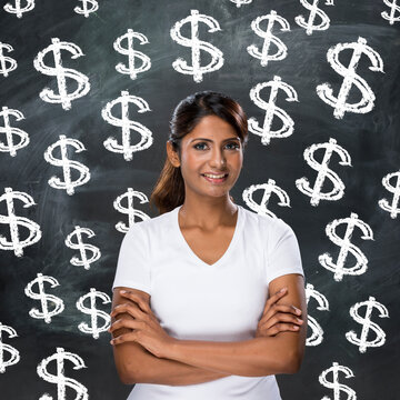Indian woman in front of dollar sign's written on chalkboard.