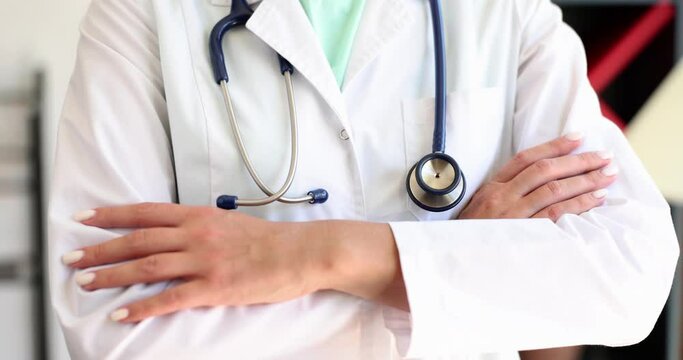 Doctor stands with arms crossed over chest in medical office. Medical assistance consultation and insurance