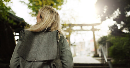 Woman, forest and torii gate in Kyoto with backpack, tourist and back with traditional history....