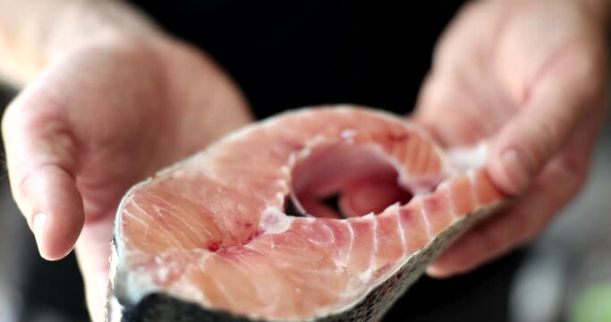 Fillet piece of salmon in hands of chef. Salmon are rich in vitamins A PP B7 and valuable fatty acids Omega-3 and Omega-6