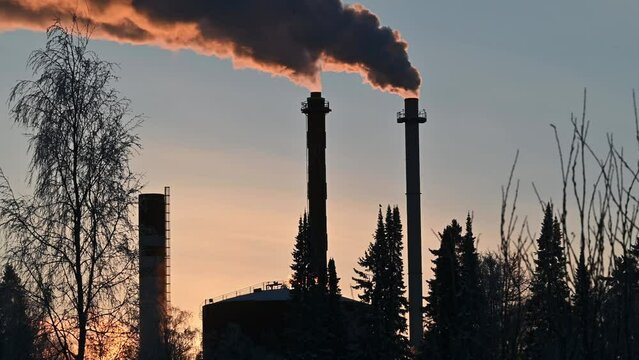 Combined heat and power plant's pipes bursting smoke into air in winter.