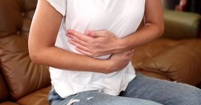 Woman holding stomach feels discomfort and pain. Health problems unhappy girl suffering from stomach pain