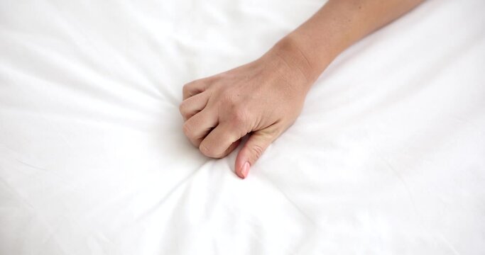 Woman orgasm sign on white bed in hotel. Intimate sex life and female libido