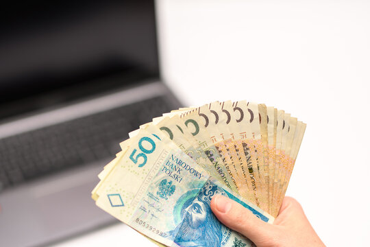 Zarabiać w internecie, branża e-comerce Got&oacute;wka w dłoni i laptop