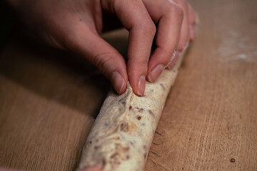 Female hands making a homemade baguette from whole grain flour. Healthy food