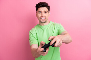 Portrait of stressed young man have fun free time gamer bite lips nervous competition cant complete level isolated on pink color background - obrazy, fototapety, plakaty