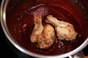Baked chicken wings covered in barbecue sauce. Glaze application stage
