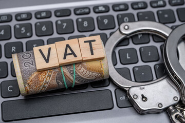 Oszustwa podatkowe vat, polskie pieniądze, kajdanki i komputer z bliska