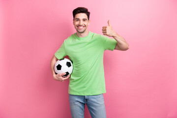 Photo of young amateur cheerful sportsman enjoying betting company holding soccer ball thumb up...