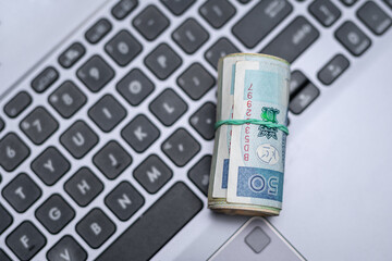 Polskie pieniądze leżą na klawiaturze laptopa, zarabiać w internecie - obrazy, fototapety, plakaty