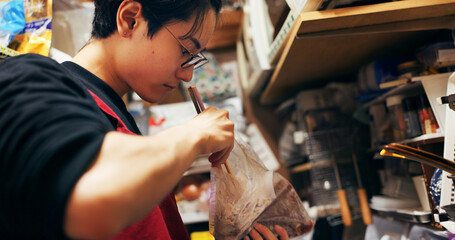 Japanese chef man, chopsticks and kitchen with plastic, search bag and thinking with stirring for...