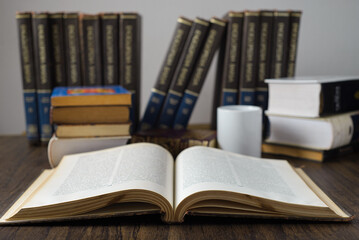 Open book on a wooden table and books in the background. World Book Day. Concept of reading.