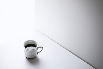 Black coffee in white ceramic mug on white background