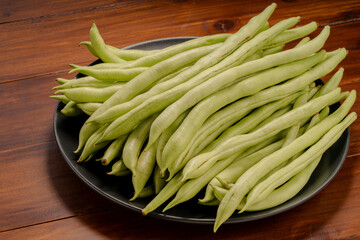 Green bean or Green pea in wooden plate on wooden background.