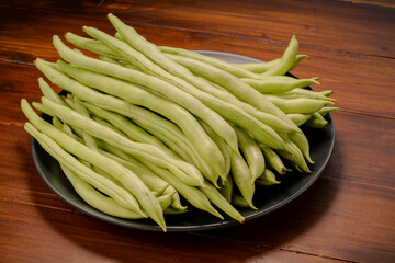 Green bean or Green pea in wooden plate on wooden background.