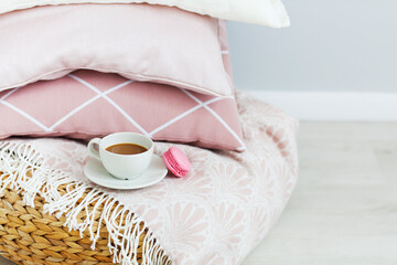 Pink and white pillows and cup of coffee on the wall background