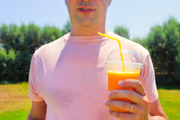 Man drinking vegetable smoothie after fitness running workout on summer day.