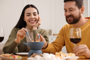 Affectionate couple enjoying fondue during romantic date at home