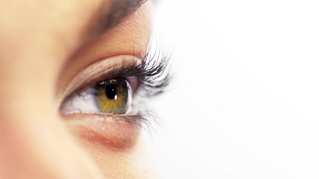 Skin, macro and eye of person thinking, vision and blinking isolated on a white studio background. Face closeup, natural and eyeball of model, human eyelashes and green iris for beauty mockup space