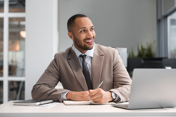 Happy man working at table in office. Lawyer, businessman, accountant or manager