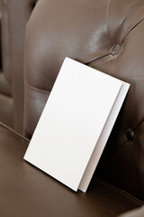 Book with blank cover on leather sofa