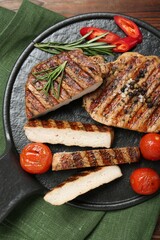 Grilled pork steaks with rosemary, spices and vegetables on table, top view