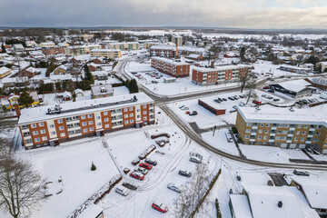 Fototapeta na wymiar Aerial view of residential area in Sweden with low-rise and private buildings during winter. Snowy weather, snowfall in a little European village, town, city.