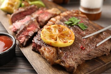Delicious grilled beef steak on wooden table, closeup