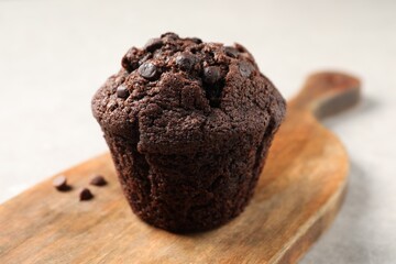 Delicious chocolate muffin on light table, closeup