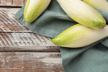 Fresh raw Belgian endives (chicory) on wooden table, top. Space for text - obrazy, fototapety, plakaty