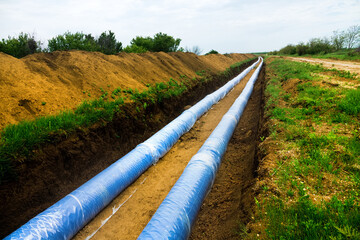 Construction of a water conduct. A double thread of large diameter water pipe is laid through plain...
