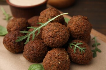 Delicious falafel balls and arugula on table, closeup