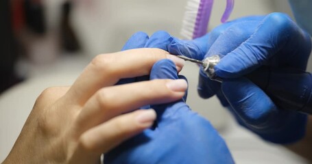 Woman in nail salon gets manicure in a beauty salon at beautician uses electric nail polish remover machine. Technology and nail care concept - Powered by Adobe