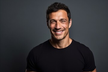 Obraz premium Portrait of a handsome young man laughing against a dark background