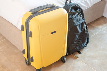 yellow suitcase on white wall background in hotel room
