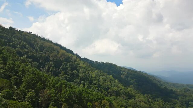 Aerial drone fly near Kew Fin viewpoint, Thailand. View of deep forest, mountains and hills in jungle. Cloudy weather.