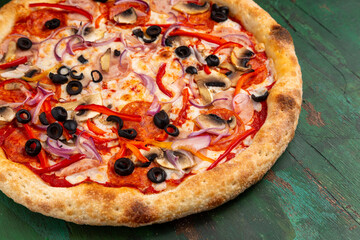 Pizza with salami, tomato, mushrooms, olives. Close-up.