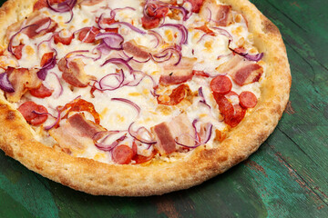 Pizza with bacon, cheese, salami and onions. Close-up.