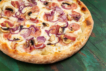 Pizza with bacon, ham, mushrooms, cheese, salami and onions. Close-up.