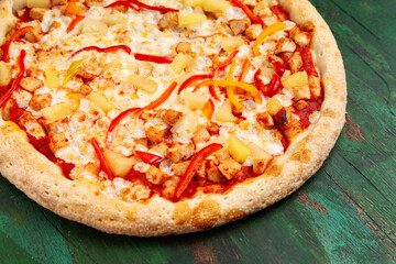 Pizza with chicken, pineapple, cheese, pepper. Close-up.
